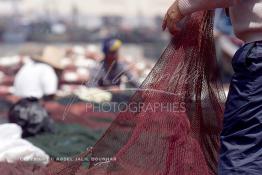 Image du Maroc Professionnelle de  Quelques ouvriers s'activent à réparer les filets de pêche sur un des quais au port d'Agadir, ville située au sud du Maroc, Vendredi 23 Août 2002. (Photo / Abdeljalil Bounhar)

 